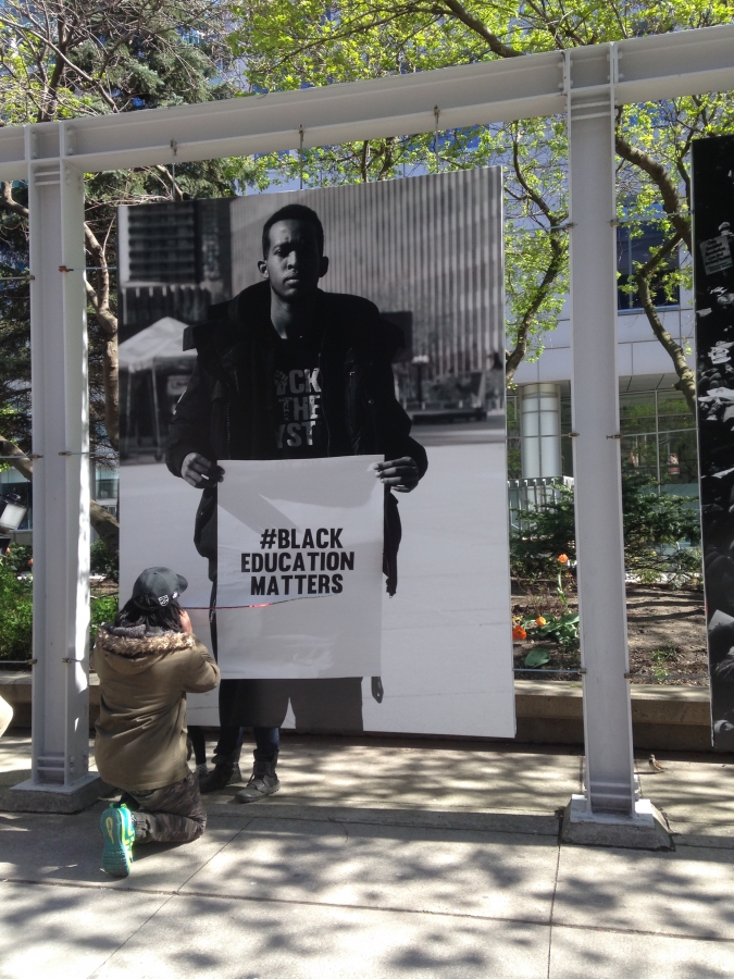 Man repairing slashed Black Education Matters photo