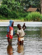 A boy proudly shows off the tiny sambaza fish he caught