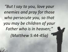 Statue of Jesus with arms outstretched with verse, &quot;Love your enemies...&quot;